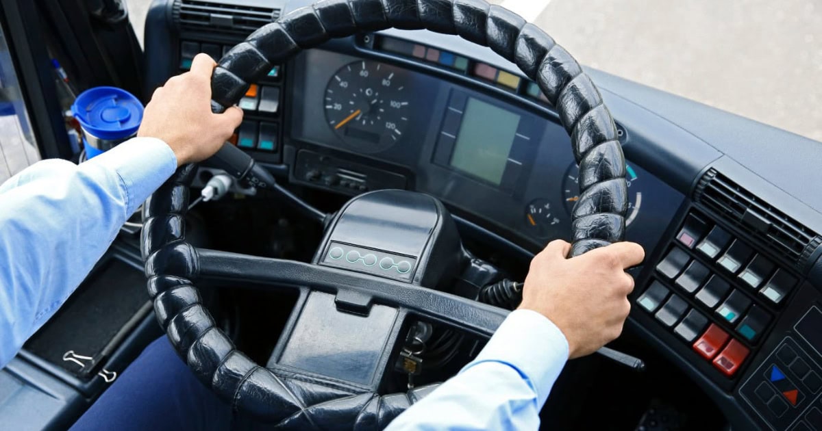 Bus driver with hands on stearing wheel